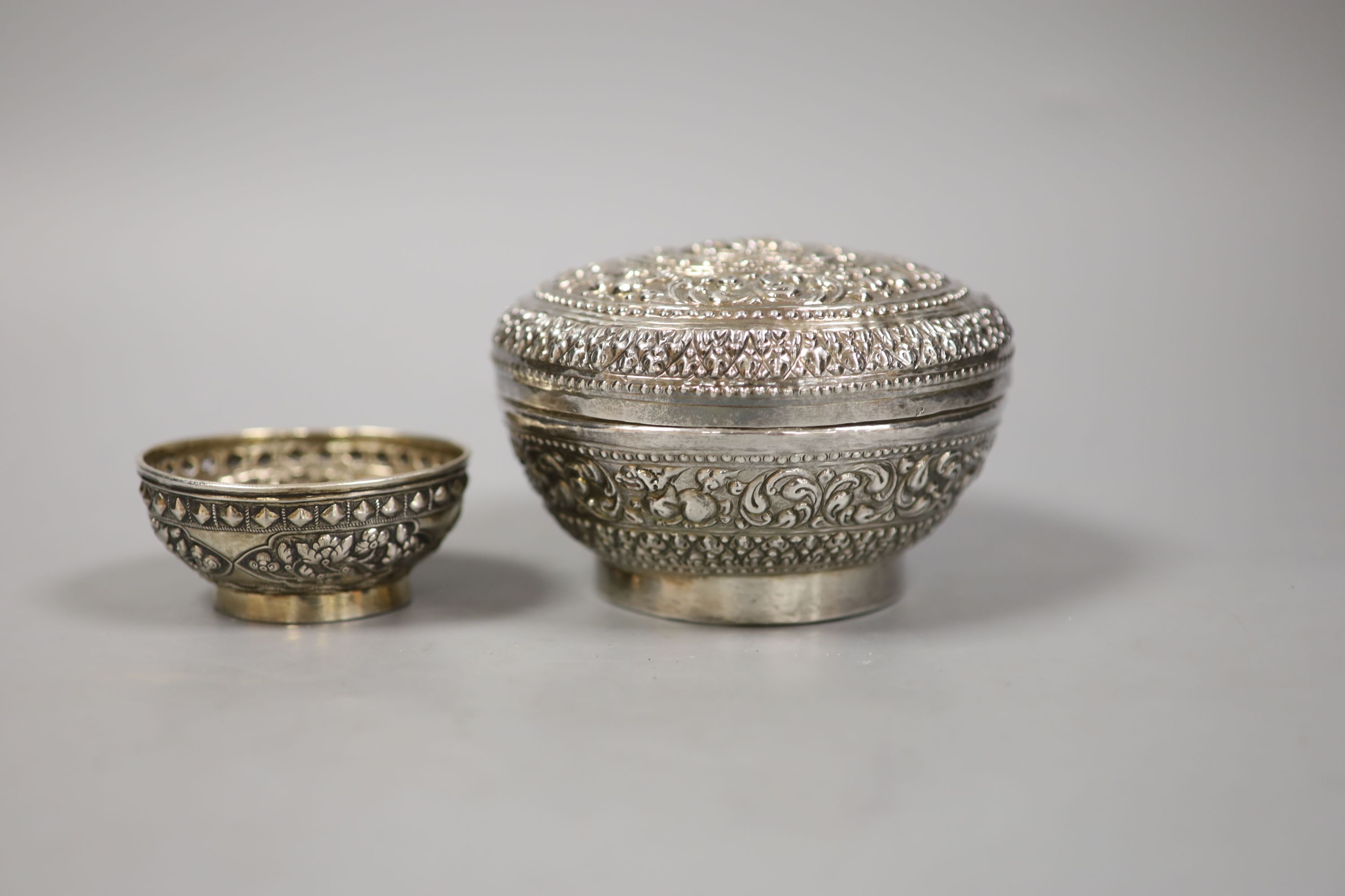 An Indonesian embossed white metal bowl and cover and two similar smaller bowls, largest diameter 13.5cm